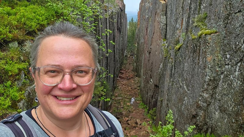 Frau steht vor der bekannsten SChlucht im Skuleskogen NAtionalpark und lächelt in die Kamera